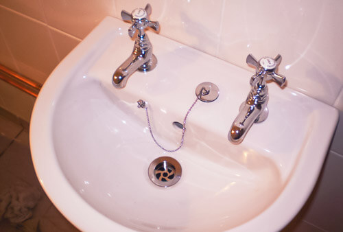 Toilet bathroom sink unit with double taps.
